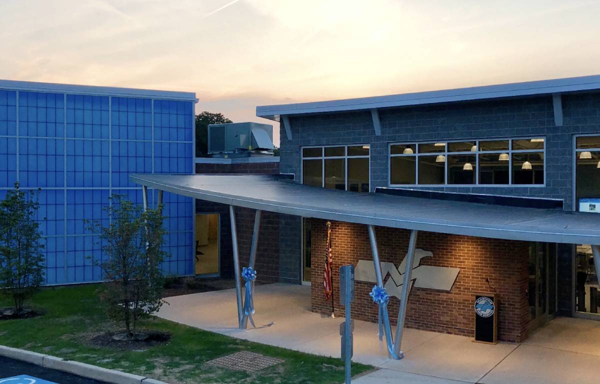 Building exterior featuring brick walls, industrial-style beams, and a covered walkway
