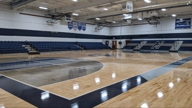 Indoor basketball court with empty bleachers, showcasing a professional sports facility and athletic space