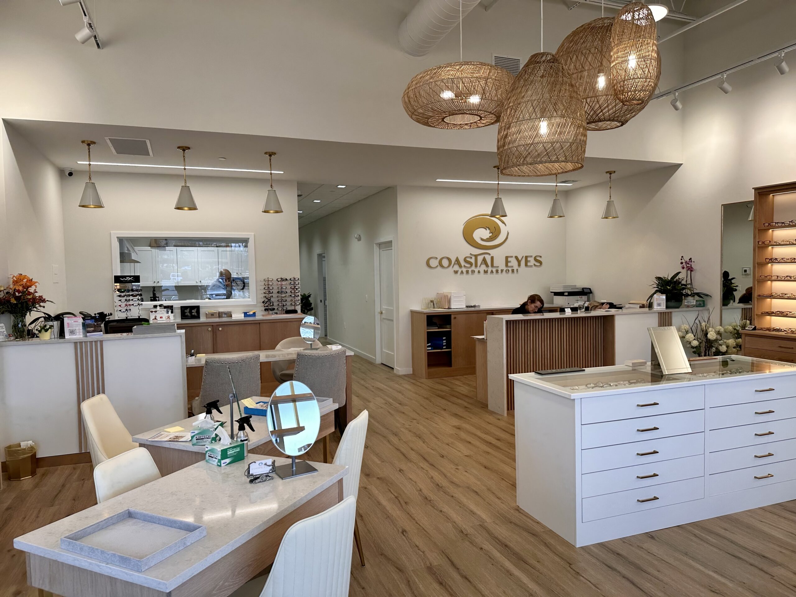 Interior of an eye care retail center featuring gold fixtures, ambient lighting, and woven basket chandeliers, showcasing luxury eyewear design and modern store aesthetics